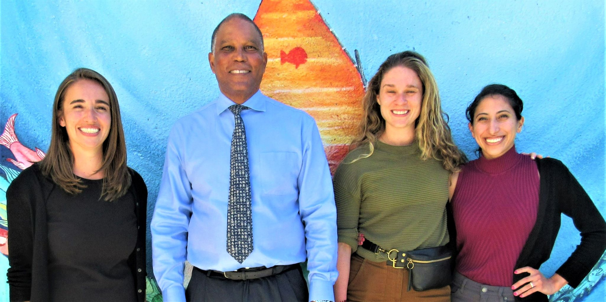 Chief residents stand with Dr. Neil Powe against bright mural background
